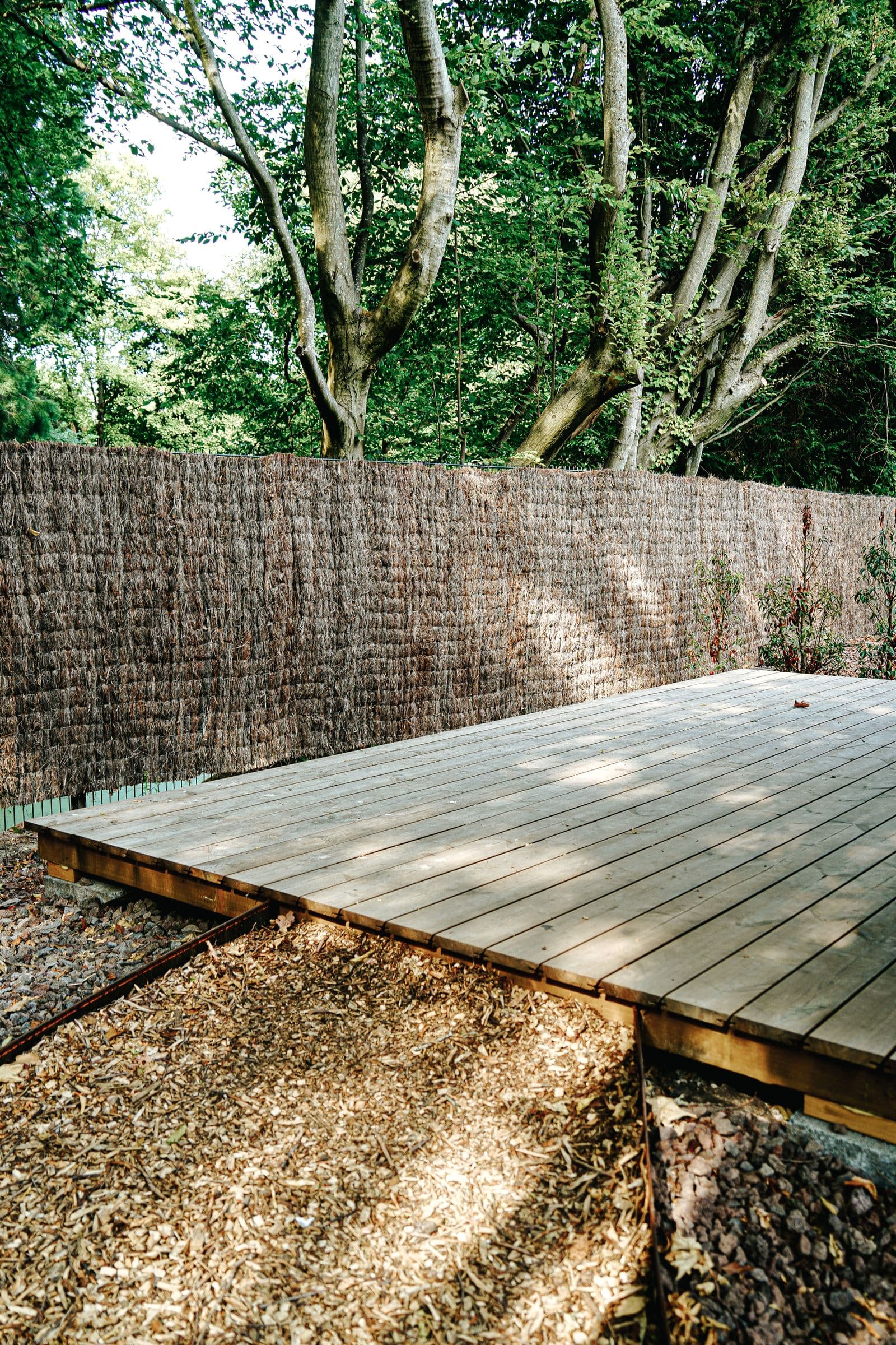 Wood deck being washed, half restored to natural color