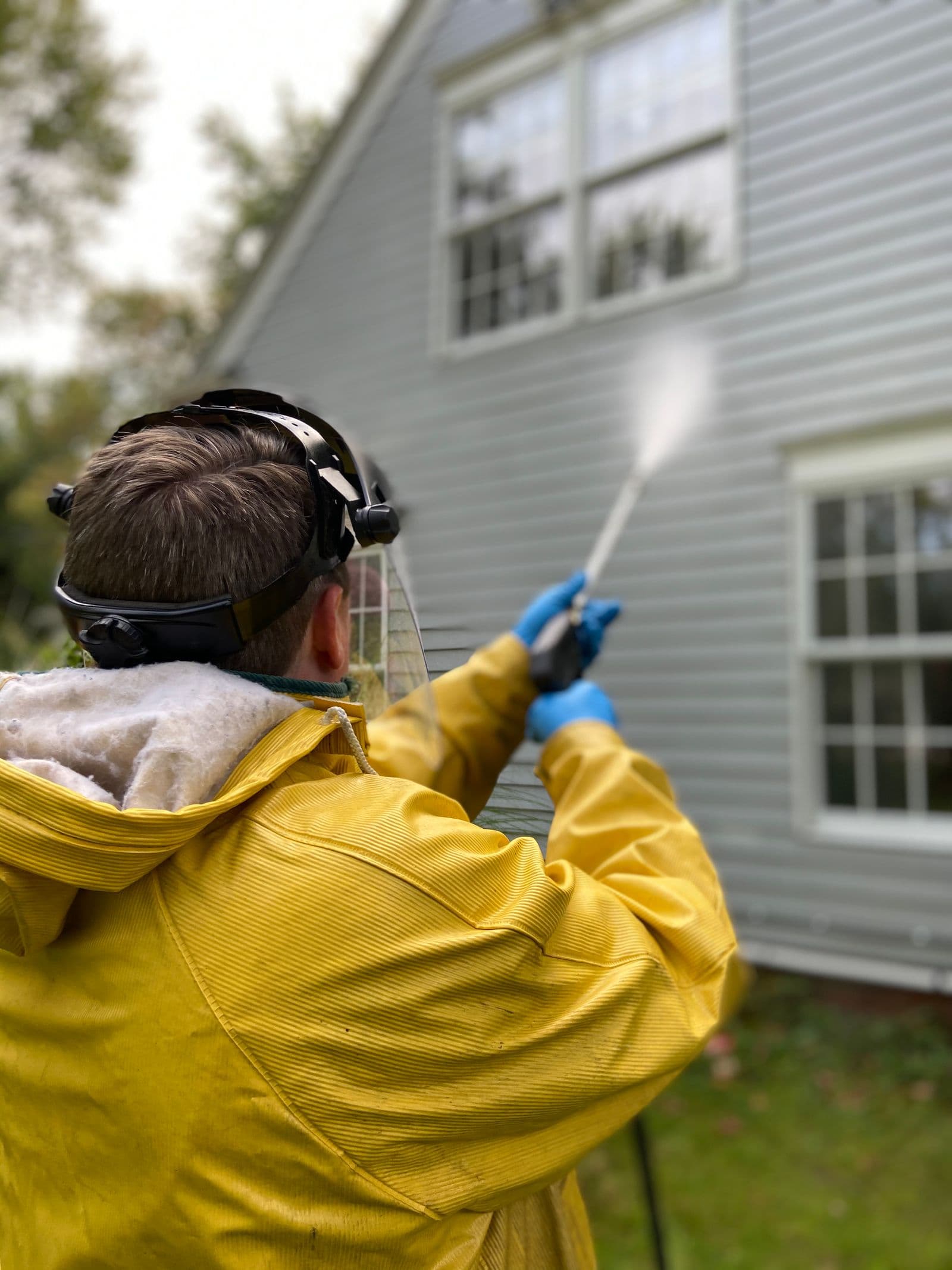 Technician pressure washing a home driveway on a sunny day